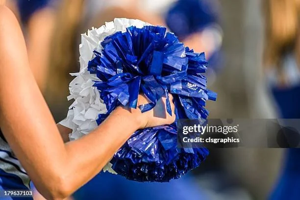 Close-up of a person's hand holding blue and white pom-poms during a cheerleading event. oms Clinic in Wheat Ridge, CO Arvada, CO Golden, CO
